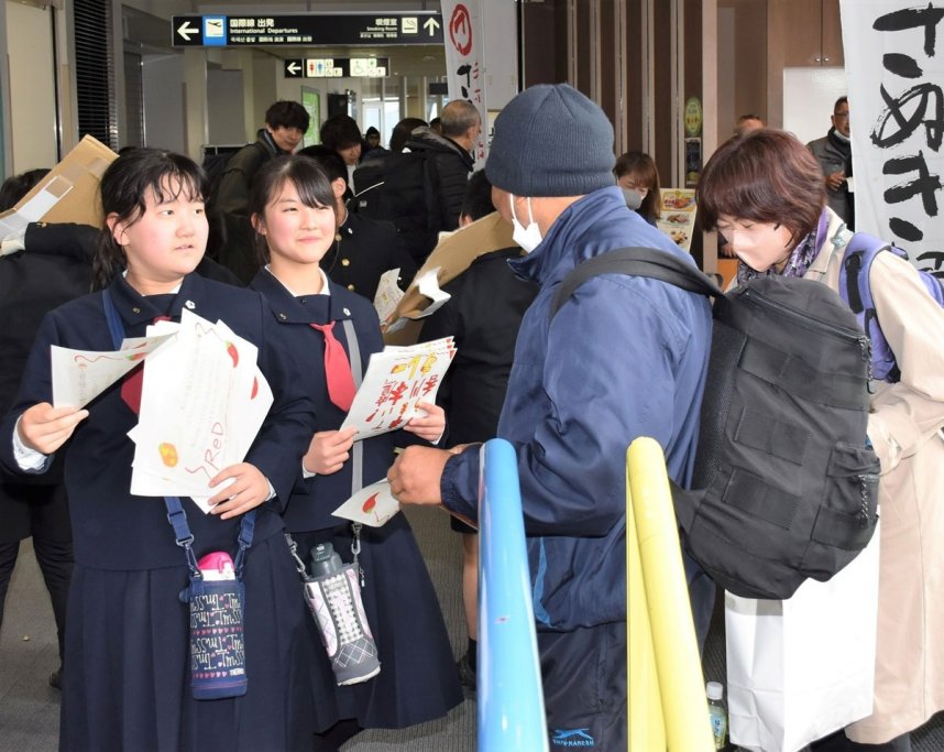 高松空港の利用客らにチラシを配って商品をＰＲする児童たち
