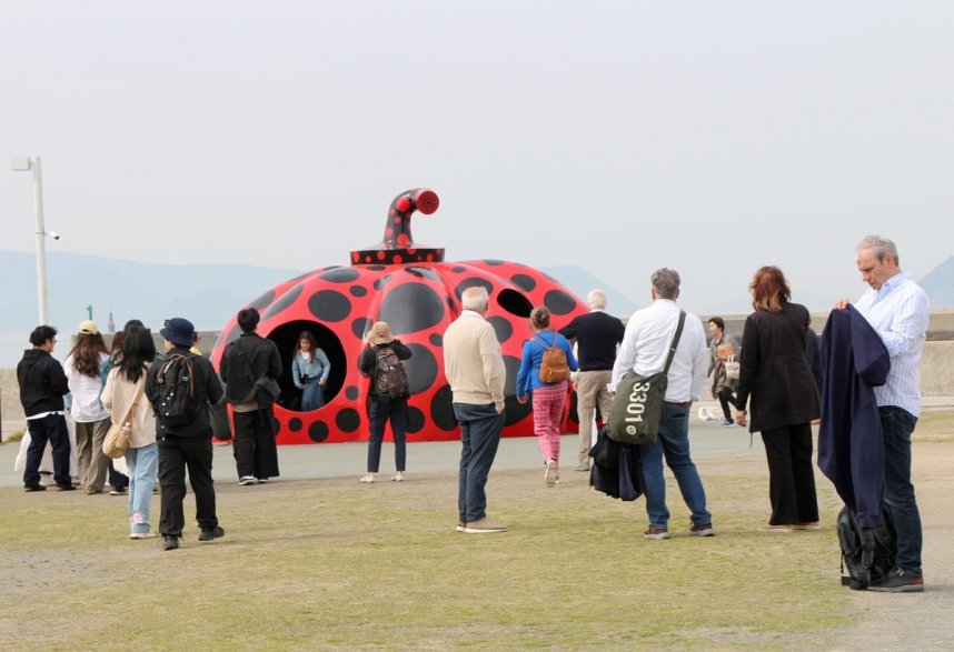 国内外の観光客でにぎわう草間弥生さんの「赤かぼちゃ」＝直島町宮浦