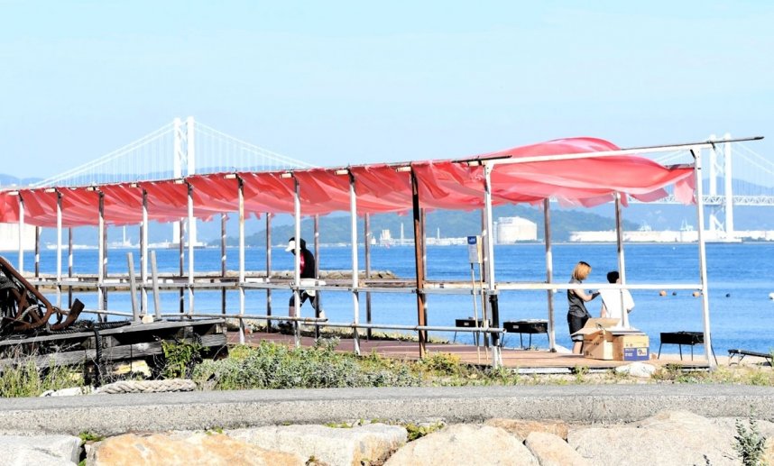 ３層に重ねた生地の屋根がなびく海の家＝香川県丸亀市本島町、泊海水浴場