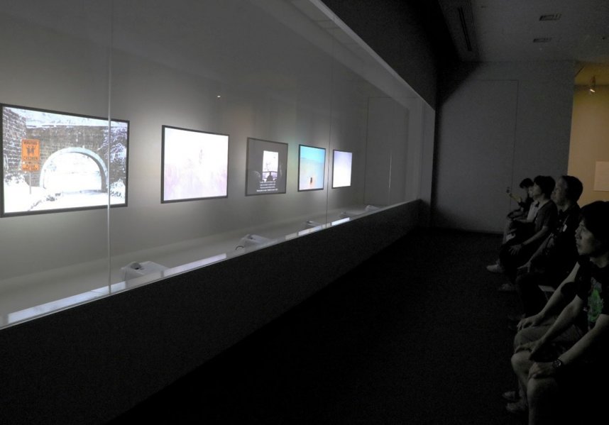 展示ケースの中に設置された映像作品に浸る来場者＝香川県高松市玉藻町、県立ミュージアム