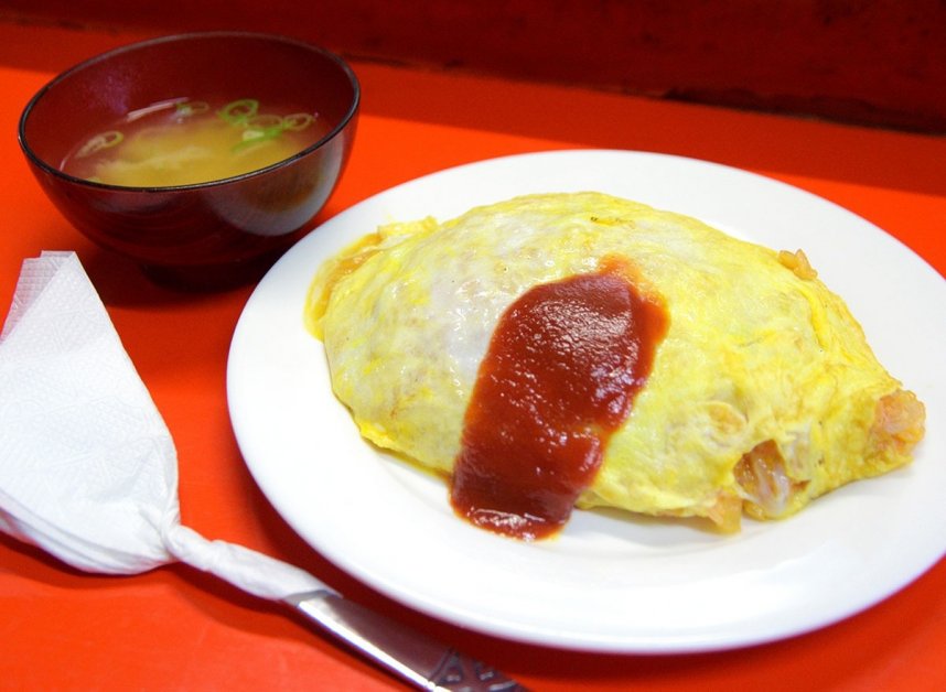 竹田さんの妙技が詰まったオムライス。紙ナプキンでくるまれたスプーンとみそ汁も「街の洋食屋さん」らしさを演出している
