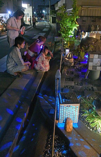 幻想的な石あかりを楽しむ家族連れ＝香川県高松市牟礼町、旧庵治街道