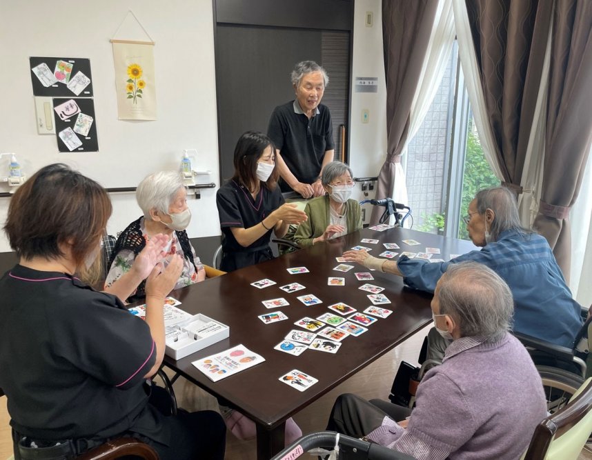 かるたに興じる入所者と制作した藤本さん（奥の男性）