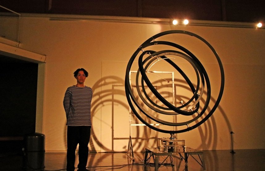 宇宙の始まりをテーマにした作品とともに写真に納まる武内＝香川県高松市塩江町、市塩江美術館