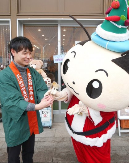 誕生日プレゼントの飴を池さん（左）から受け取るさかいでまろ＝香川県坂出市元町