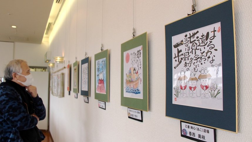地蔵や七福神のイラストが描かれた色紙作品に見入る来場者＝香川県高松市玉藻町、ギャラリーカフェ「シレーヌ」