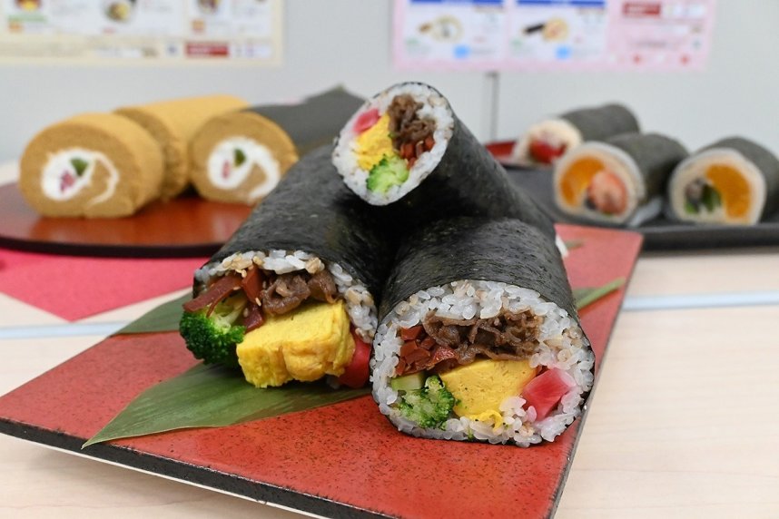 ダイシモチ麦を米に混ぜ込んだ酢飯を使った「さぬきもち麦しあわせ巻」（手前）と「さぬき恵方ロール」（後方）