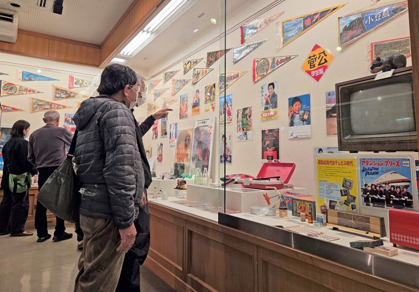 思い出話に花を咲かせながら展示品を楽しむ来館者＝香川県仲多度郡多度津町家中、町立資料館