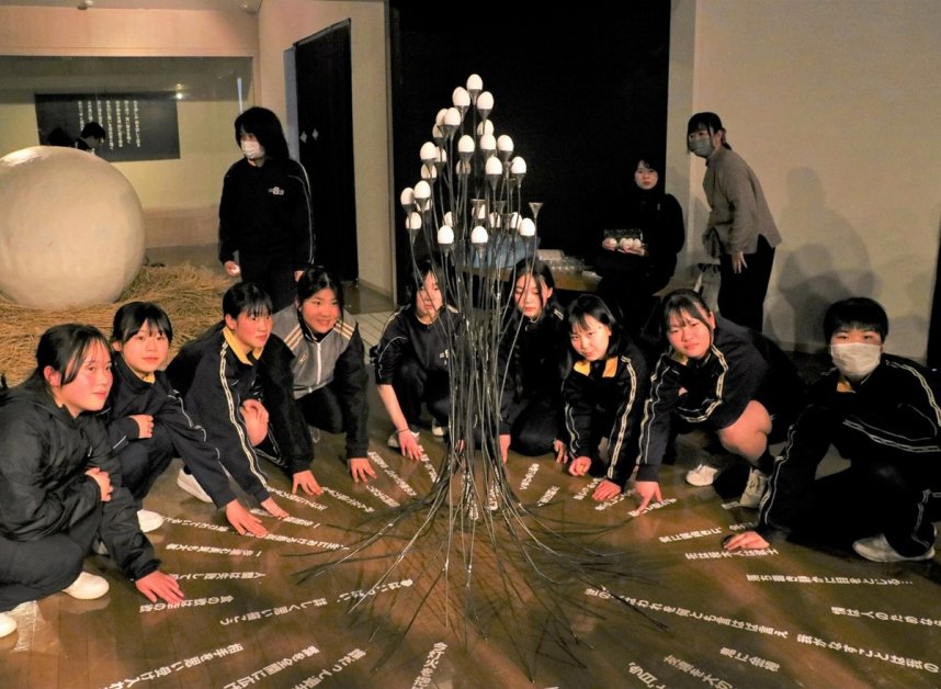 言葉のシートを床に貼り付ける生徒＝香川県高松市塩江町、市塩江美術館