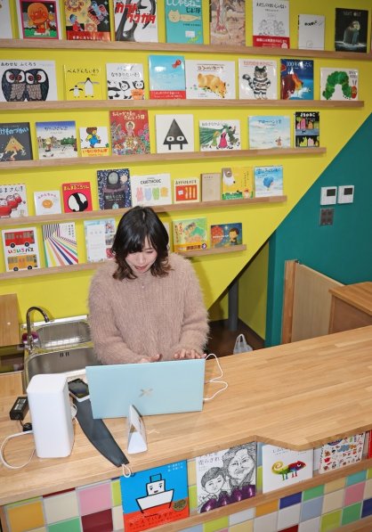 入り口のカウンターはカラフルな内装に。絵本も展示している＝香川県高松市田町