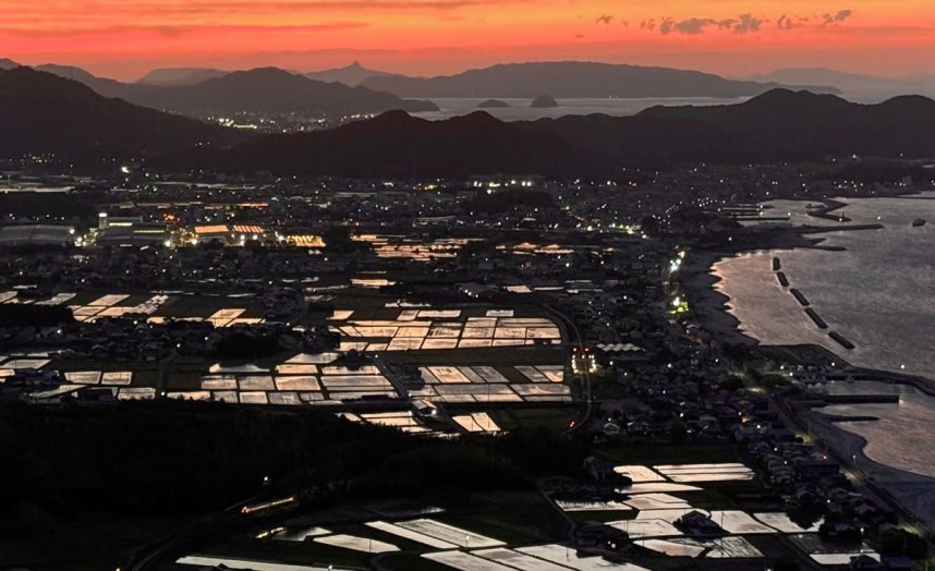 大坂峠園地の展望台から見下ろす水田に夕焼け空が映り込む＝香川県東かがわ市坂元