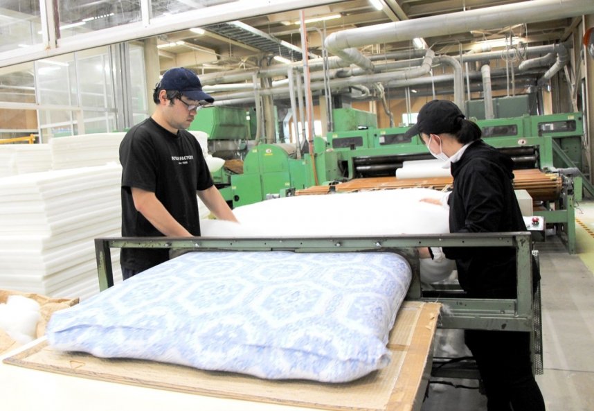 次々と流れてくる綿を手際よく詰めていく＝香川県高松市香川町、四国繊維販売