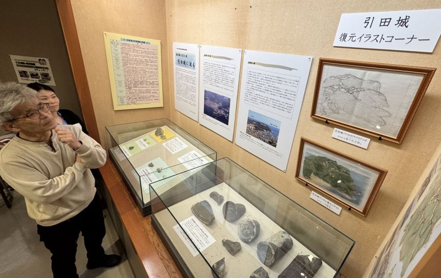 引田城の復元イラストに興味深げに見入る人たち＝香川県東かがわ市引田、市歴史民俗資料館
